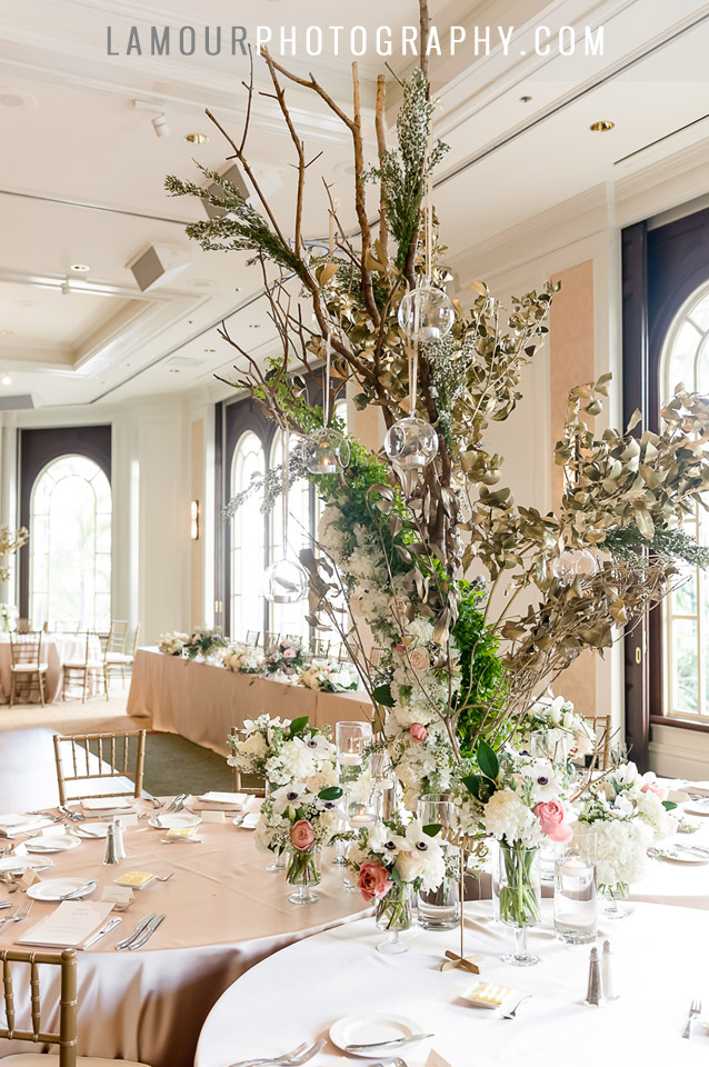 tall wedding centerpiece with hanging glass tea lights and blush pink and gold tables at Moana Surfrider in Hawaii