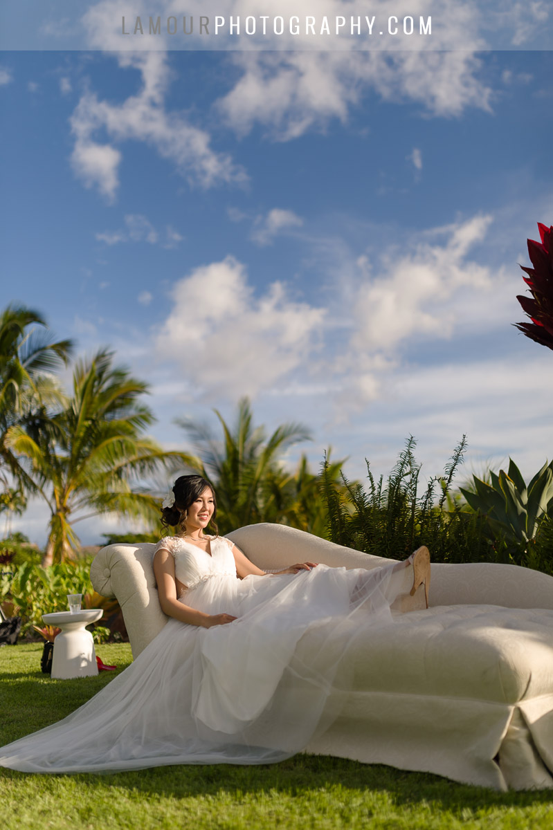Bride lounging on chaise chair for reception in hawaii wedding 