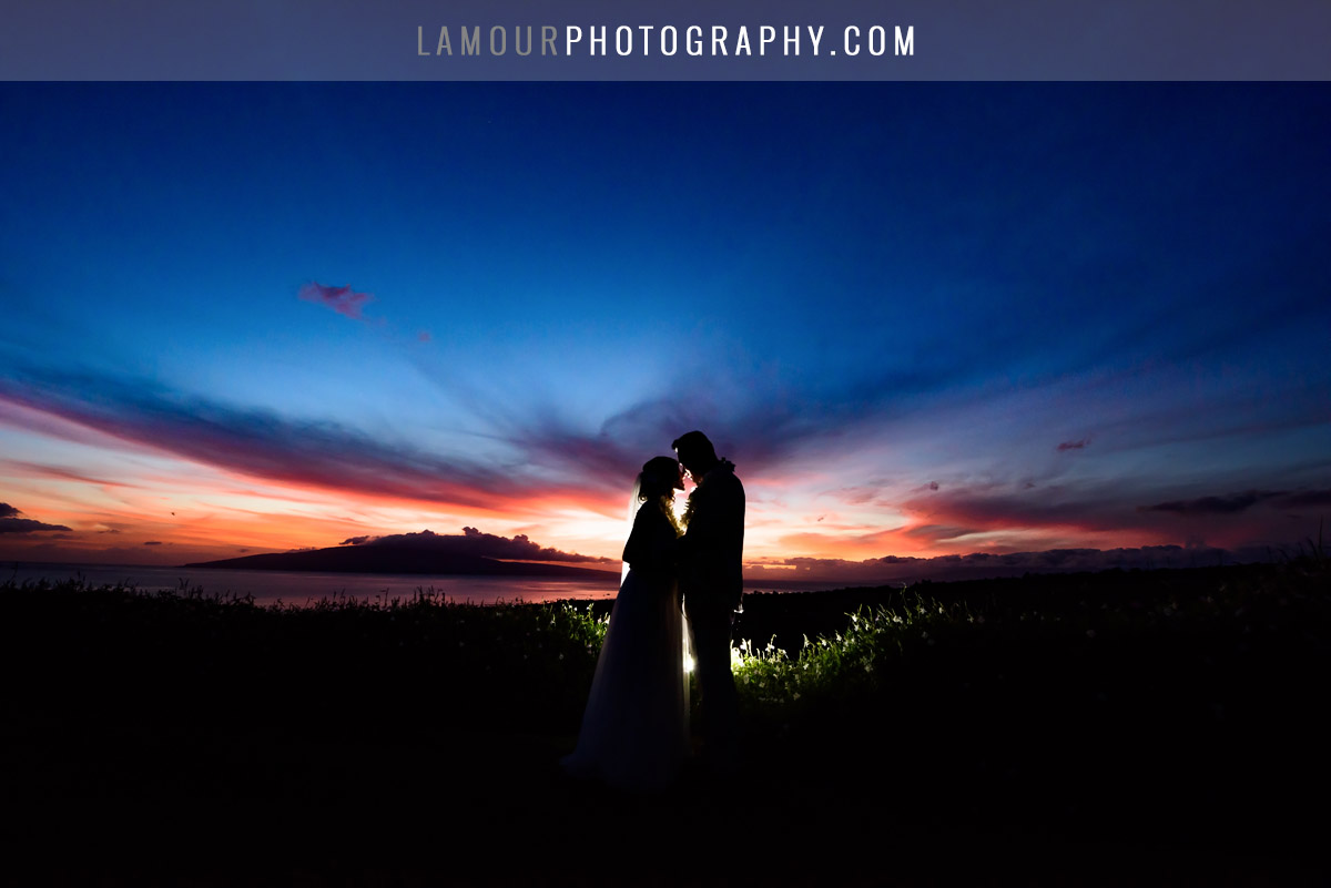 bride and groom in hawaii wedding kiss at sunset in maui