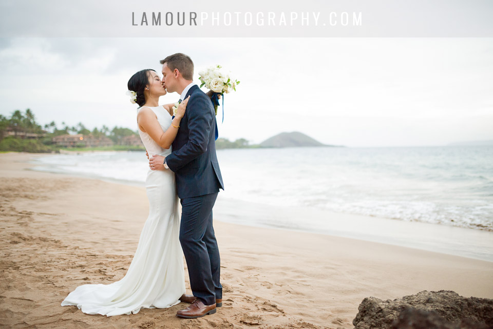 Hawaii wedding bride and groom kiss on the beach in Maui during their portrait session