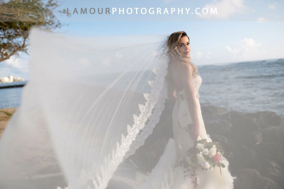 Long flowing, lace trim veil on bride for her destination wedding in hawaii on the island of oahu photographed by the team at L'amour