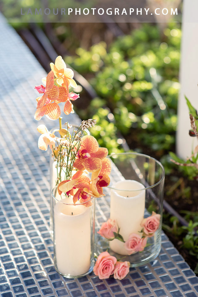 Hawaii wedding reception flowers in Oahu with candles, orchids and roses in glass vases