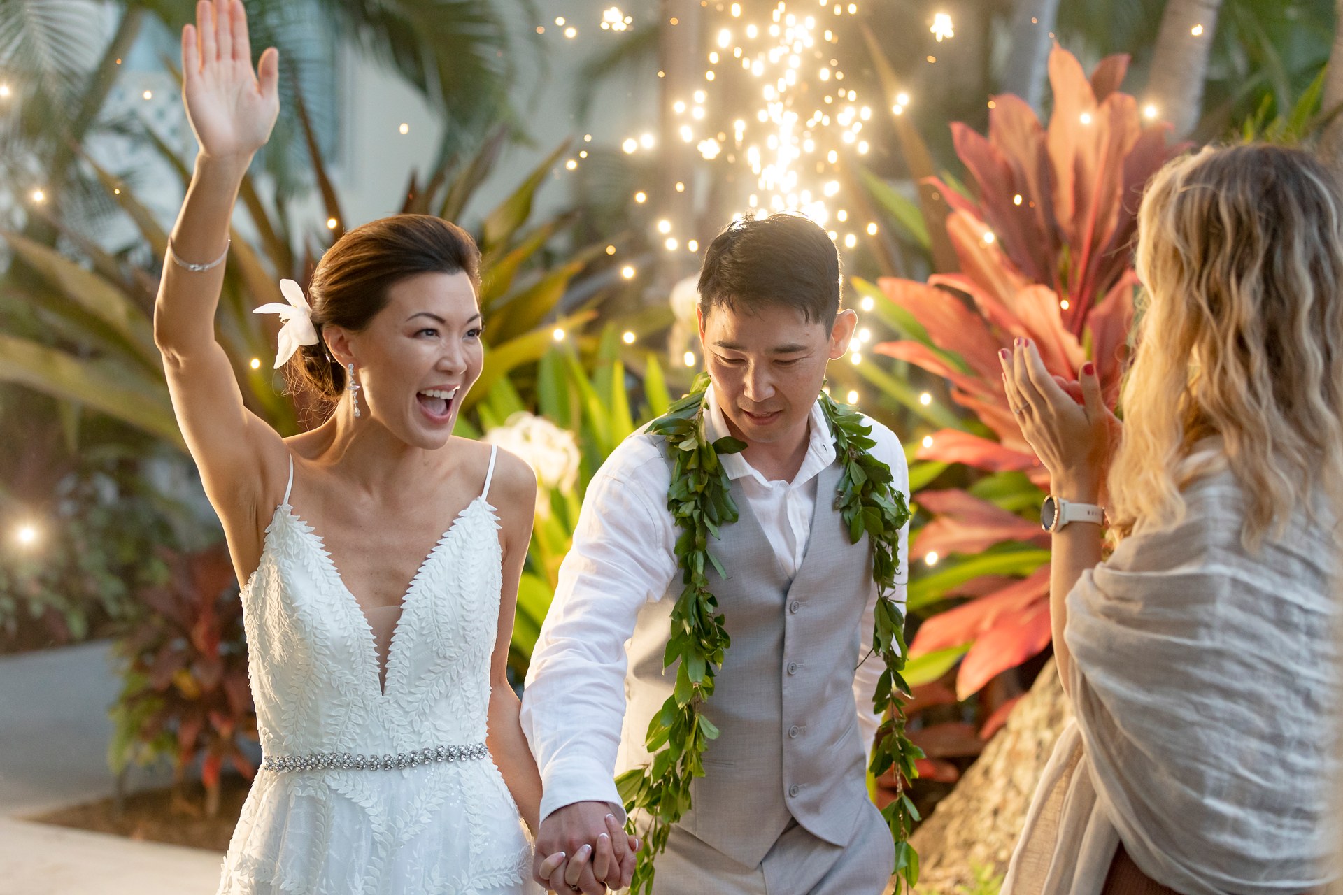 Bride cheering with the groom and a guest at their reception