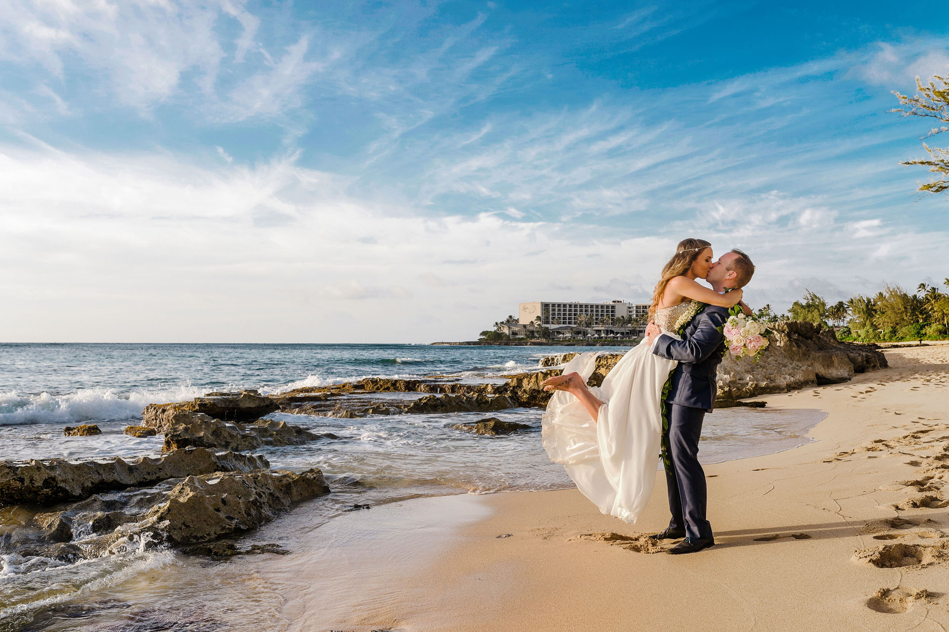 Groom lifting the bride on the beach at Turtle Bay